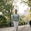 Adult walking in a quiet Manhattan park in soft morning light, taking a deliberate daily walk as part of a resilience-building routine