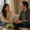 Two adults sitting close together on a soft sofa in a sunlit Manhattan living room, in calm conversation, suggesting secure connection.