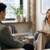 A young adult speaking calmly with a therapist in a bright Manhattan office