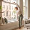 A calm person stretching by a sunlit window in a modern Manhattan apartment