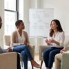 Diverse adults seated in a circle with a clinician during a DBT skills group in a bright Manhattan therapy room
